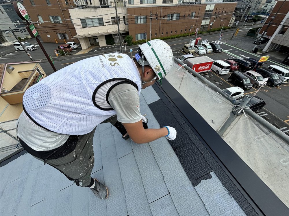中塗りで屋根全体に塗膜の厚みを持たせ、色むらが出ないよう丁寧に塗り進めます。 写真