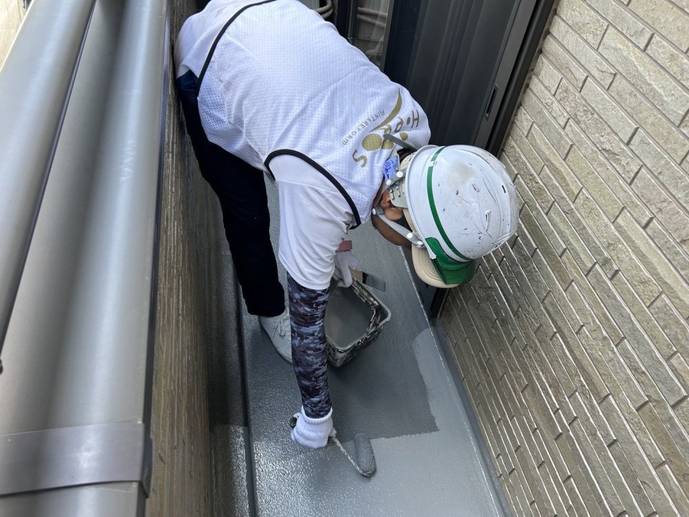 ベランダ床へトップコートを塗布し、防水層を紫外線や歩行時の摩耗から保護します。 写真