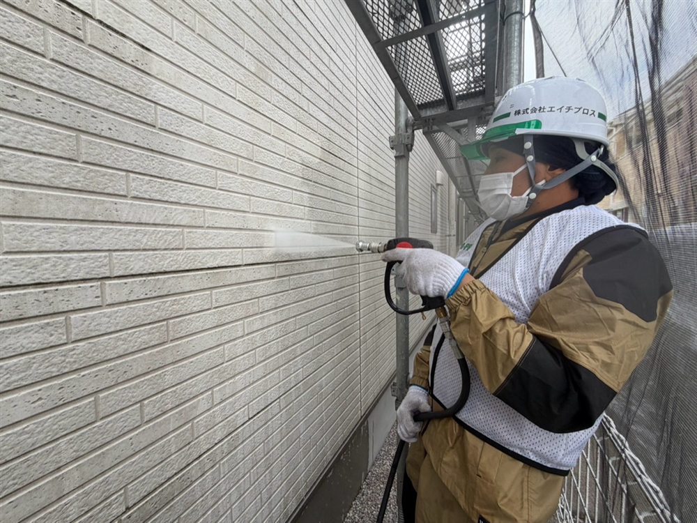 高圧洗浄で外壁のコケや汚れ、古い塗膜表面の付着物を丁寧に除去します。 写真