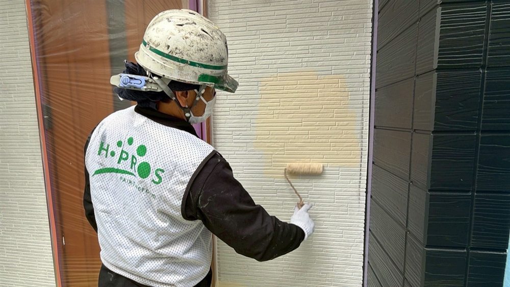 外壁の中塗りを行い、塗膜の厚みと均一性を確保します。 写真