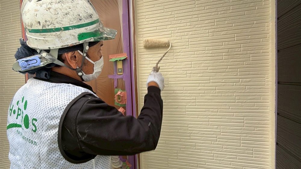 外壁の上塗りを行い、淡いピンク系の美しい色合いに仕上げます。 写真
